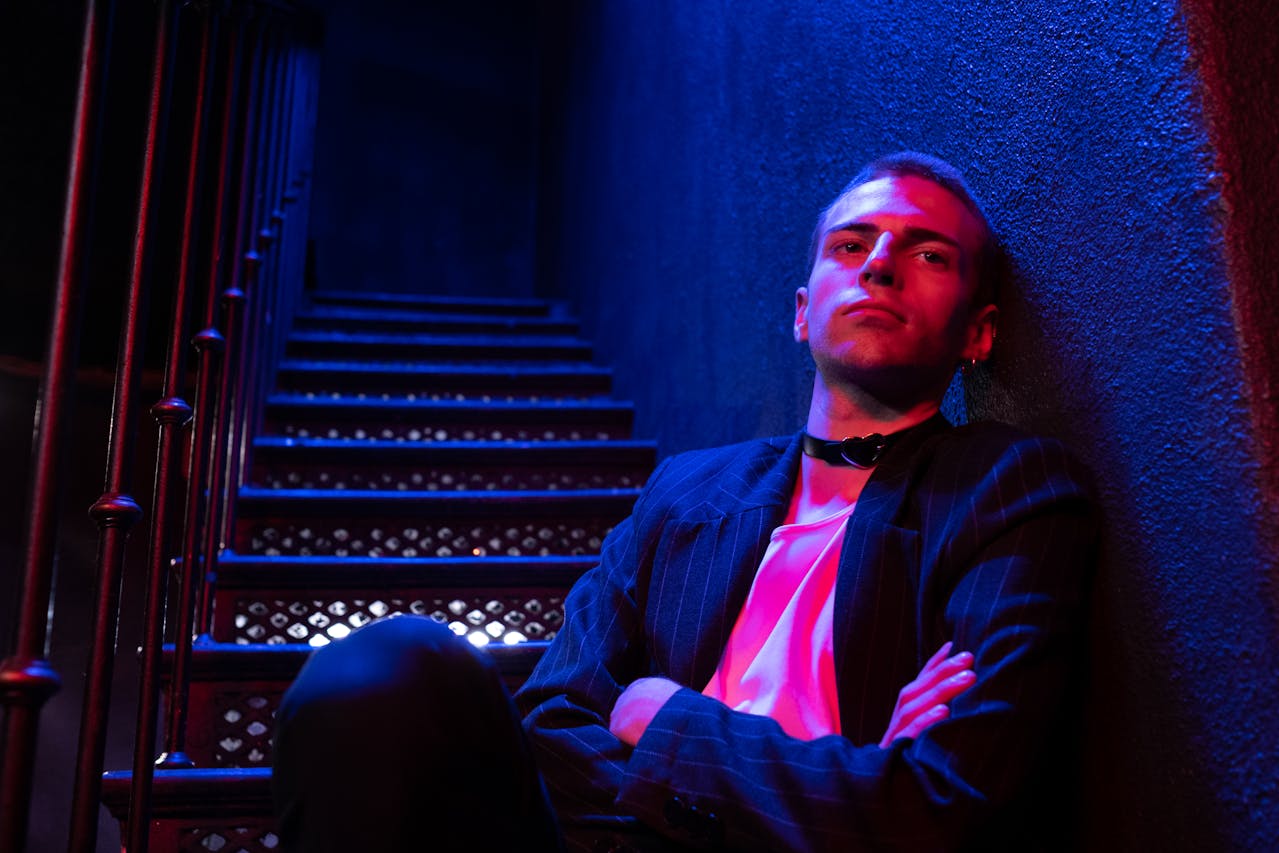 Mann auf Treppe in pink-blauem Licht