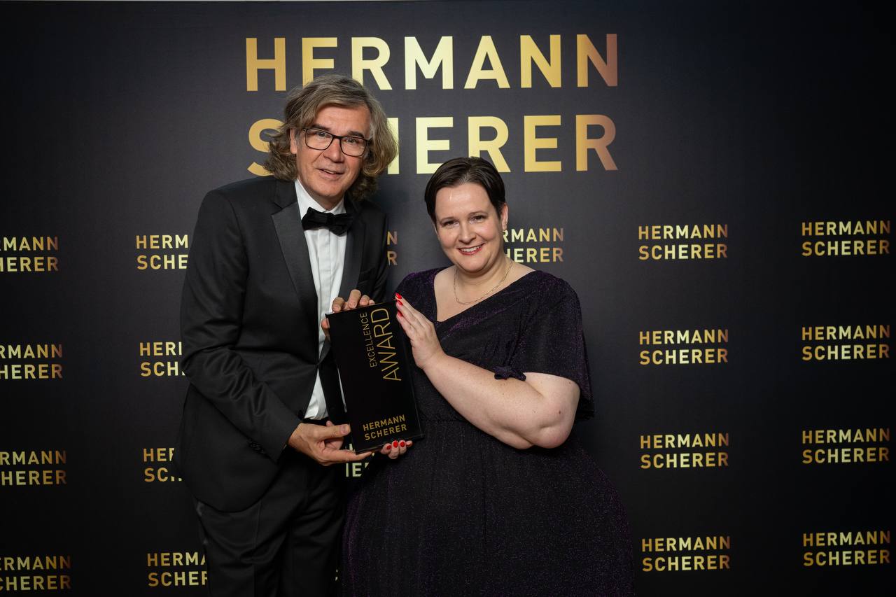 Jana Stöcker hält den Excellence Award mit Helmut Scherer